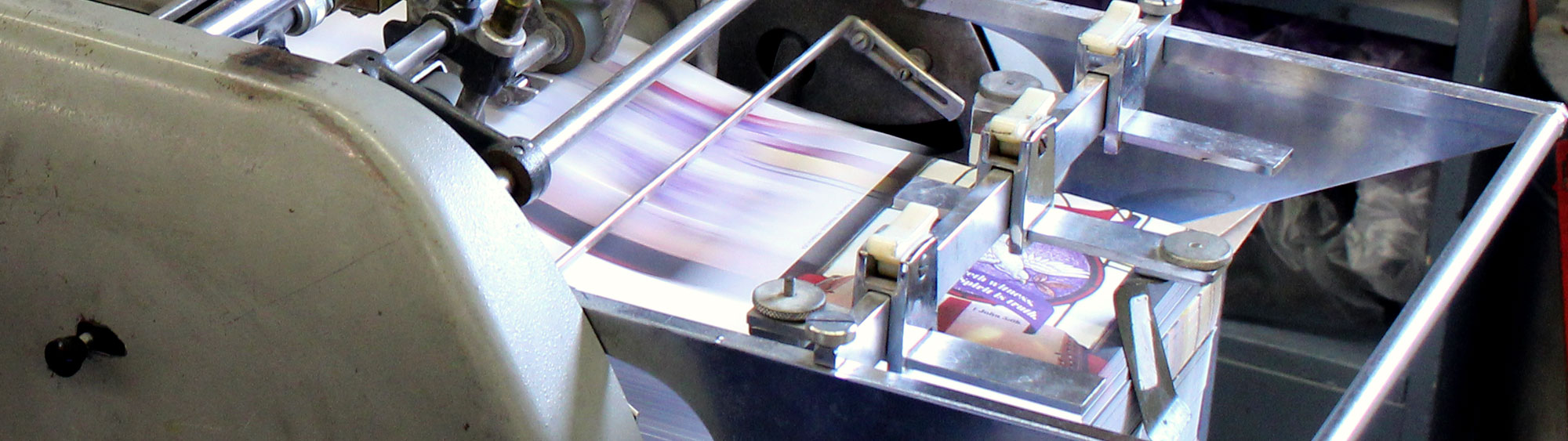 Weekly Church bulletins being printed in a commerical printer at Cathedral Press in Long Prairie, MN